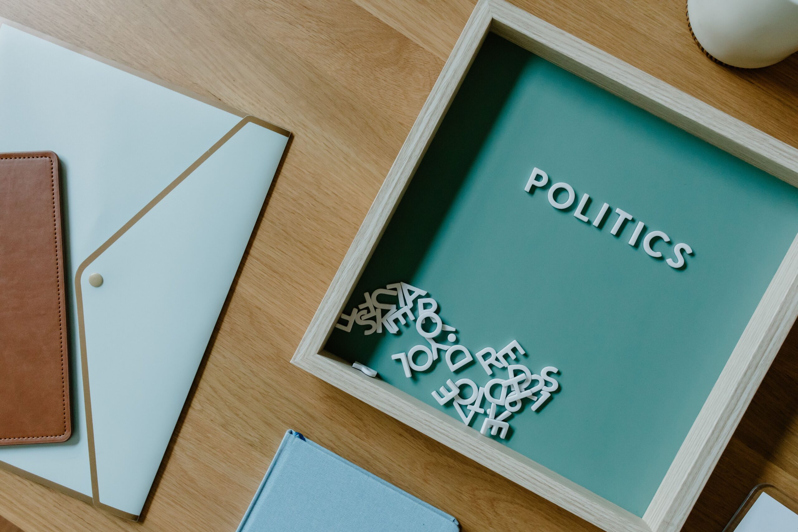 Top view of a box with the word biopolitics alongside office items on a wooden desk. Licensed by Pexels.